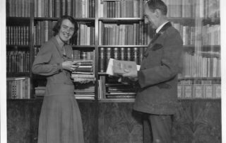 young woman with her father in front of bookshelves