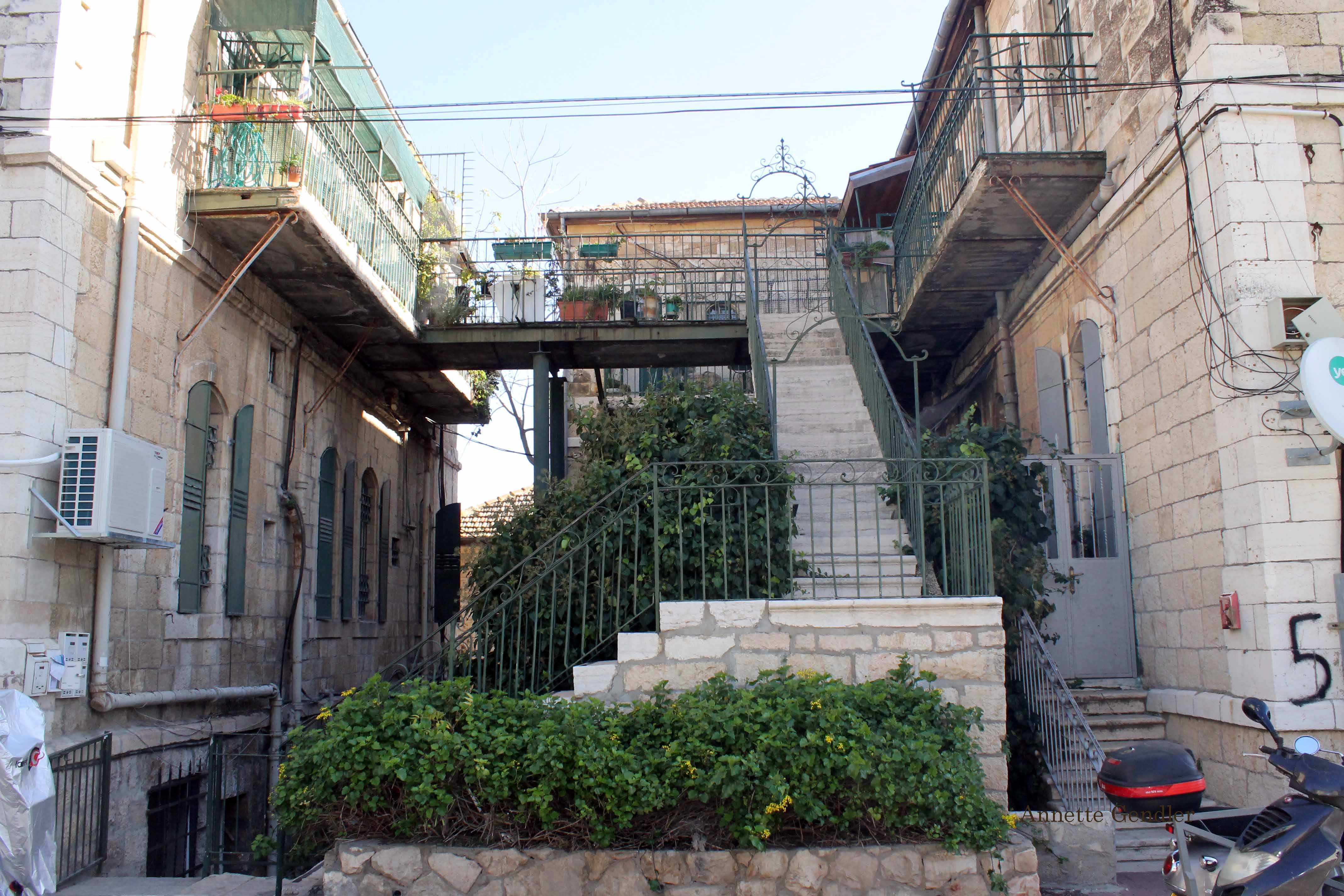 Two old Jerusalem houses in Musrara connected by outside limestone stairs with ironwork railings