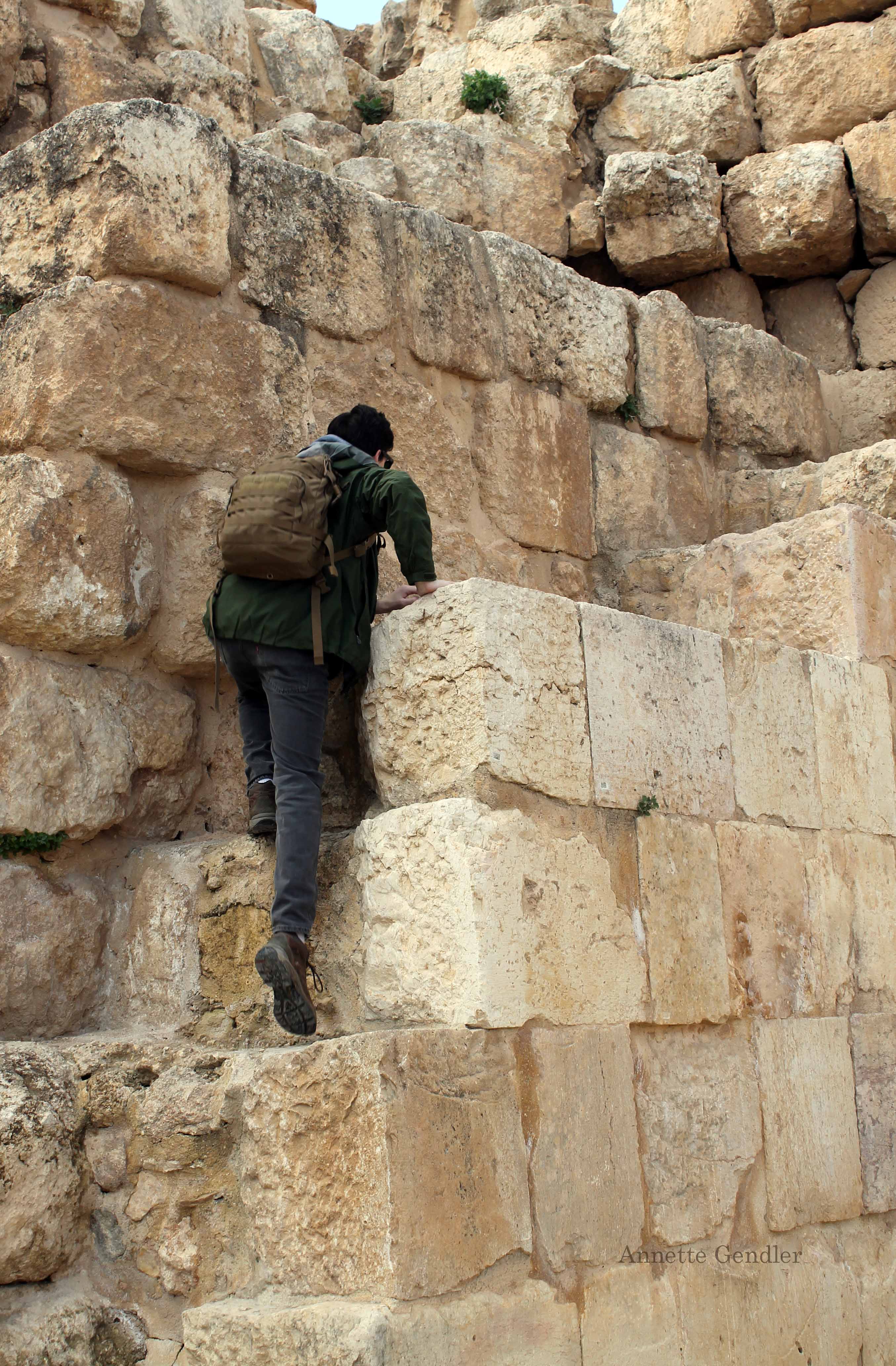 A young man climbs the Temple of Zeus ruins in Jerash, Jordan