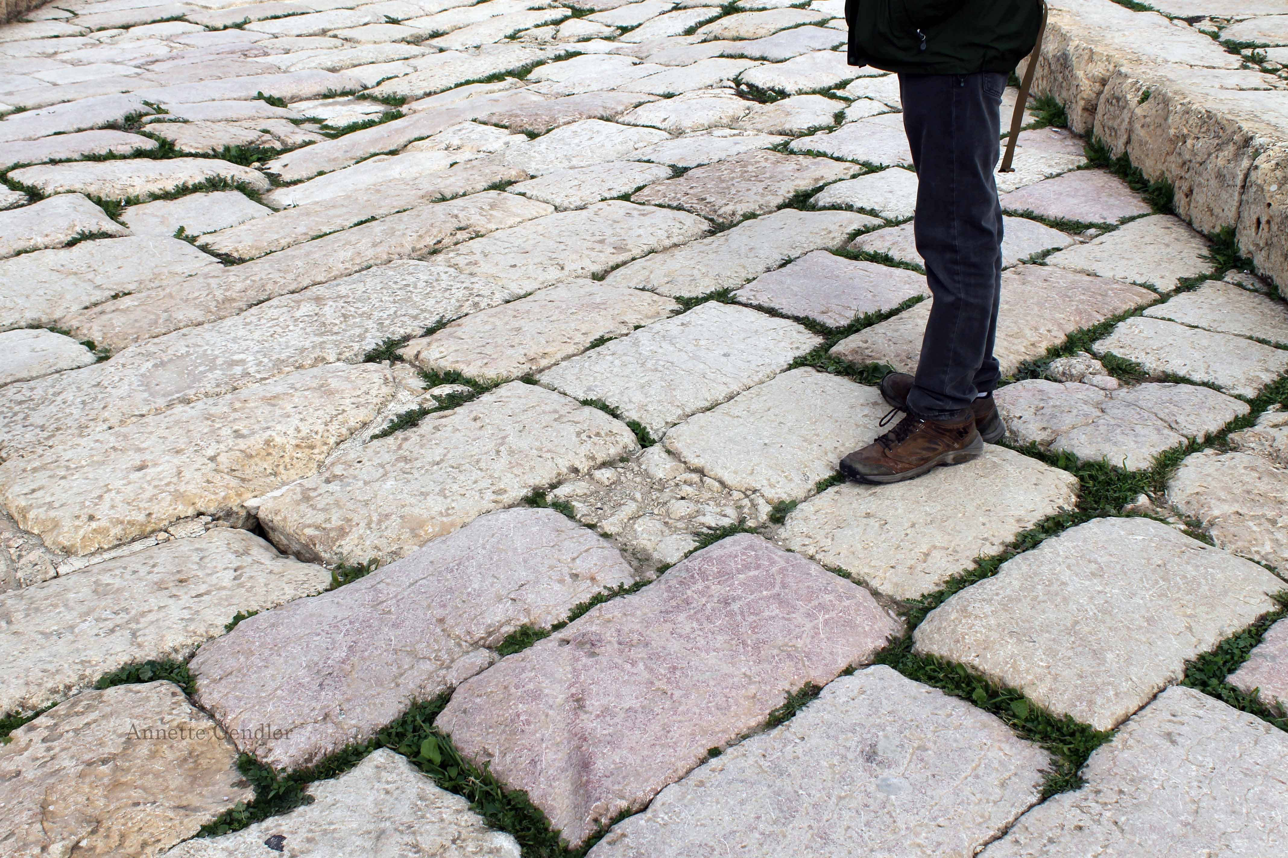 Roman pavement, wavy from earthquake, seen with person standing on it