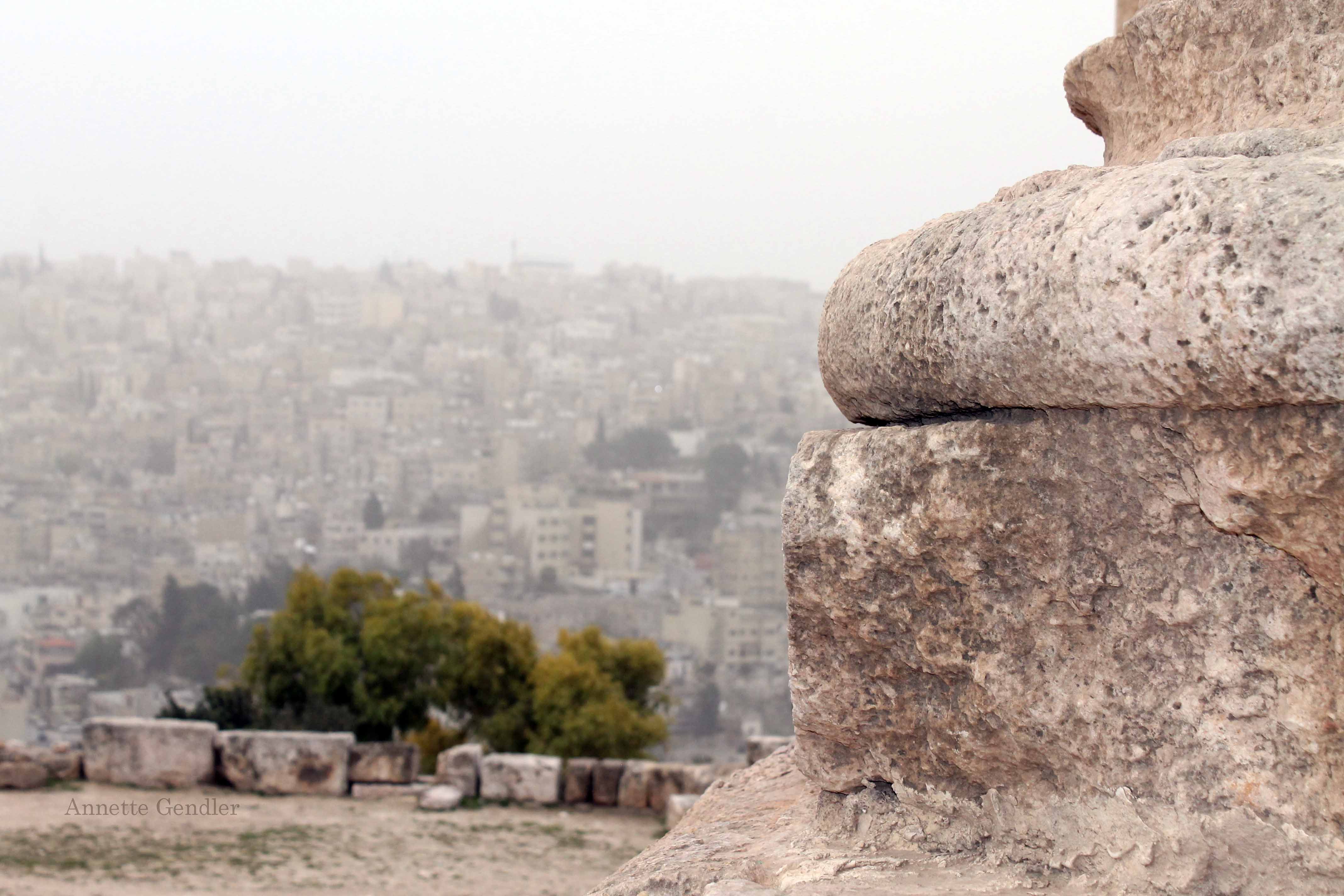 Roman column in foreground, view of city of Amman in background