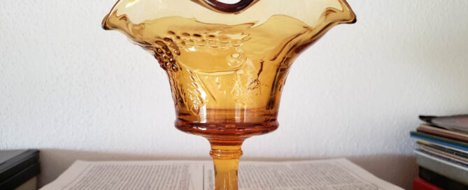 amber glass candy dish in front of white background