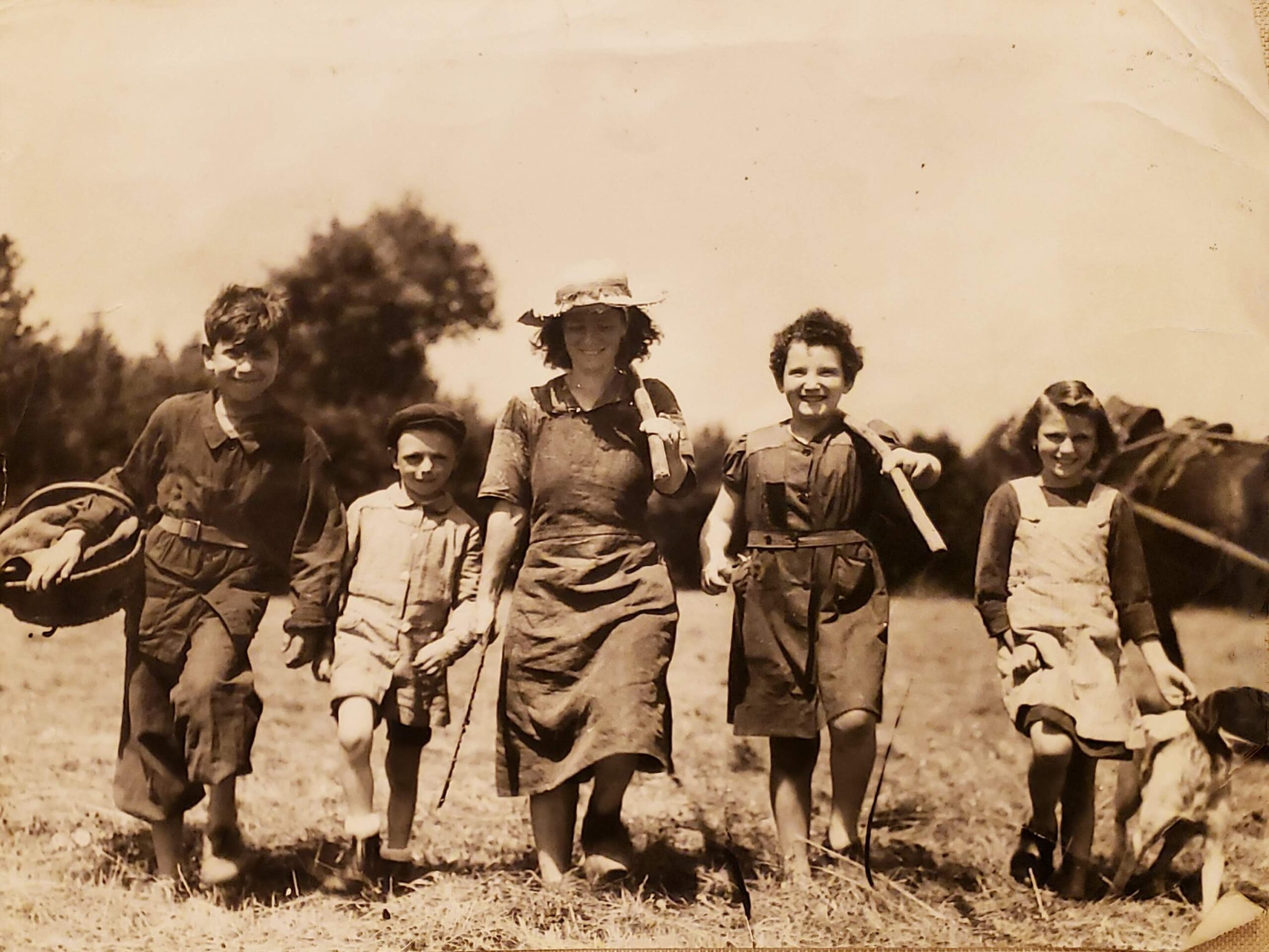 black and white picture of a woman running with four children in the French countryside