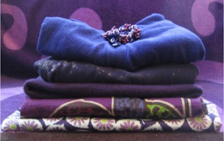 stack of purple sweaters and fabric