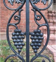 black wrought iron fence with grape motif