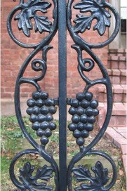 black wrought iron fence with grape motif