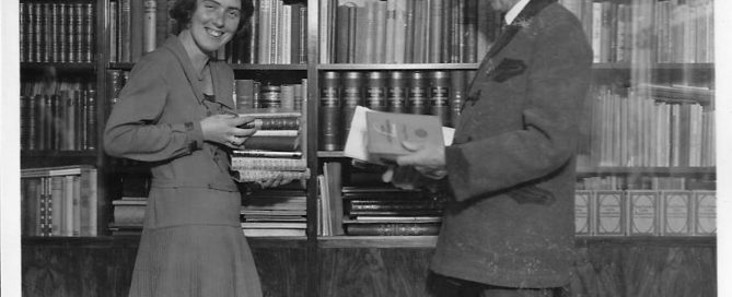 young woman with her father in front of bookshelves