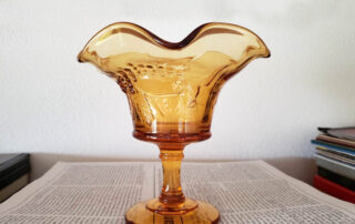 amber glass candy dish in front of white background